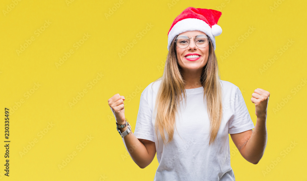 Young beautiful woman wearing christmas hat over isolated background celebrating surprised and amazed for success with arms raised and open eyes. Winner concept. Young beautiful woman wearing christmas hat over isolated background celebrating surprised and amazed for success with arms raised and open eyes. Winner concept.