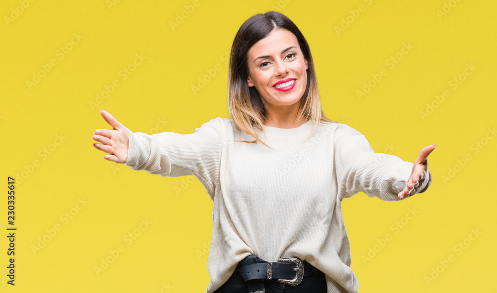 Young beautiful woman casual white sweater over isolated background looking at the camera smiling with open arms for hug. Cheerful expression embracing happiness. Young beautiful woman casual white sweater over isolated background looking at the camera smiling with open arms for hug. Cheerful expression embracing happiness.