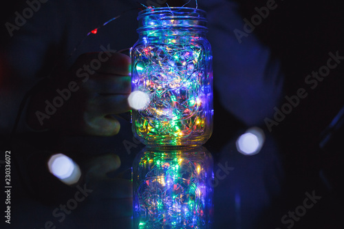 kids holds Christmas lantern in hands on lights bokeh background. New year celebration concept, festive mood