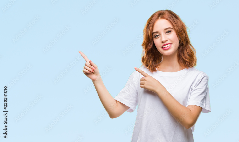 Young beautiful woman over isolated background smiling and looking at the camera pointing with two hands and fingers to the side. Young beautiful woman over isolated background smiling and looking at the camera pointing with two hands and fingers to the side.