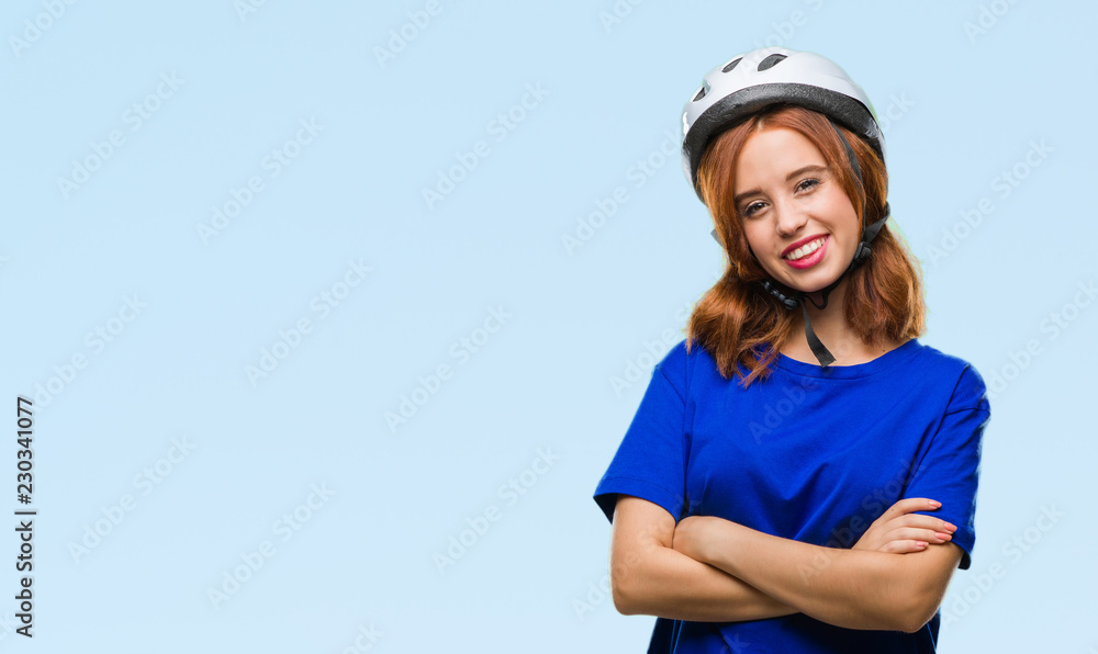 Young beautiful woman wearing cyclist helmet over isolated background happy face smiling with crossed arms looking at the camera. Positive person. Young beautiful woman wearing cyclist helmet over isolated background happy face smiling with crossed arms looking at the camera. Positive person.