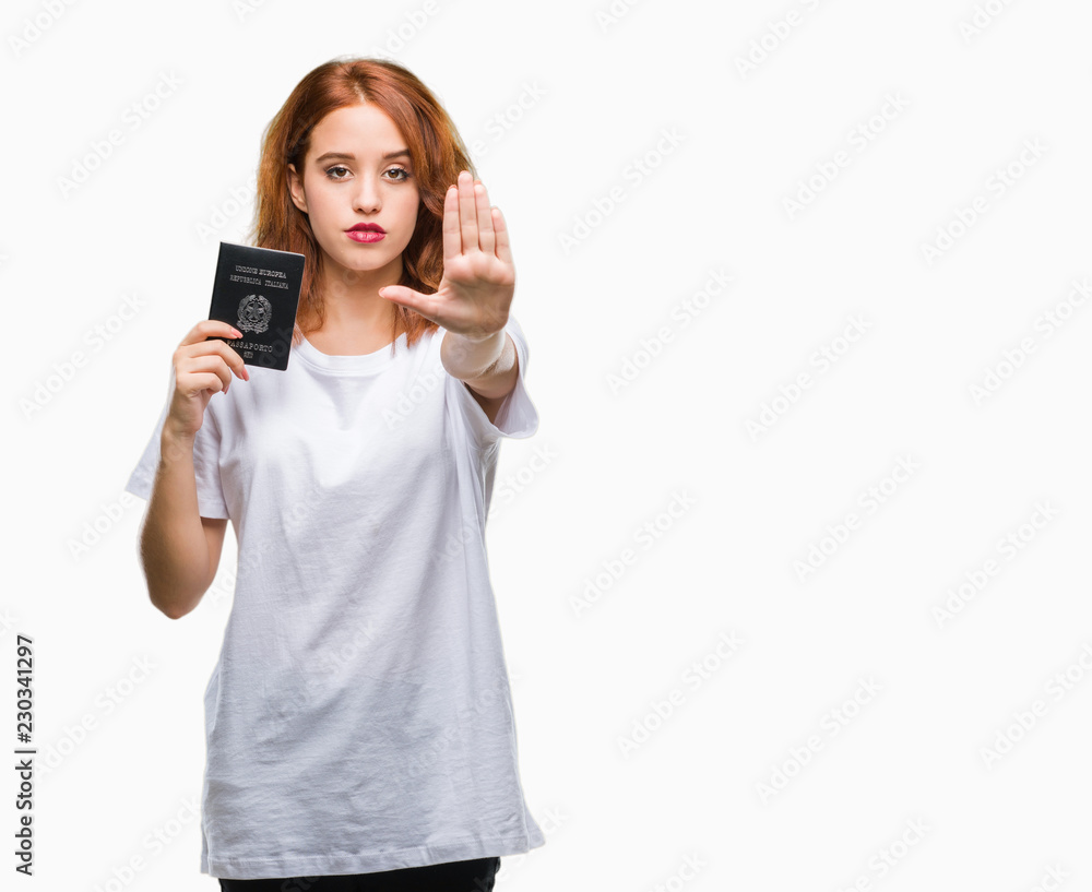 Young beautiful woman holding passport of italy over isolated background with open hand doing stop sign with serious and confident expression, defense gesture Young beautiful woman holding passport of italy over isolated background with open hand doing stop sign with serious and confident expression, defense gesture