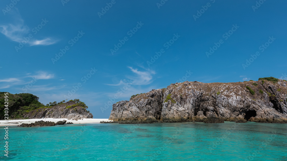 scenery of rocky island with clear blue sea and blue sky