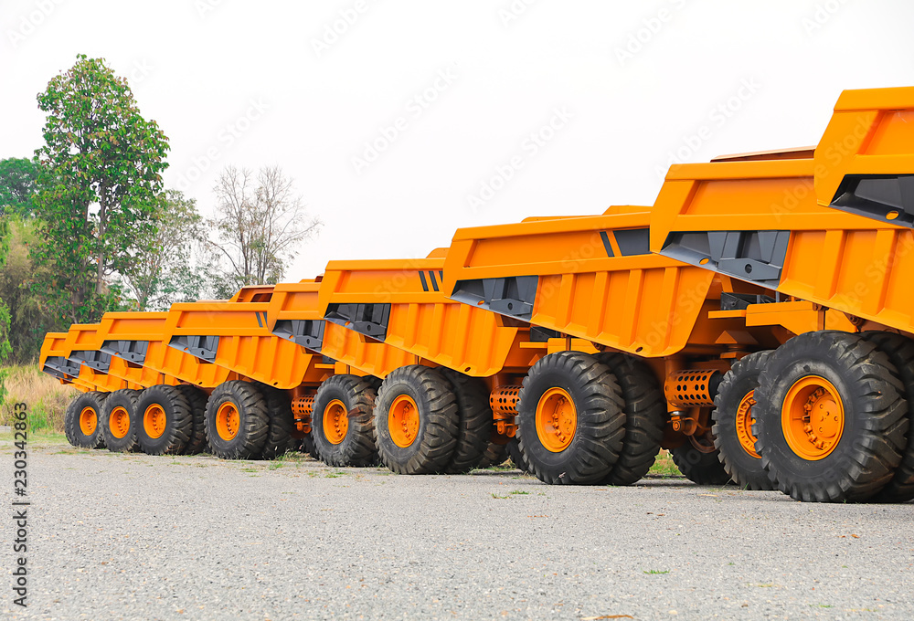 Big dumper trucks parked on a construction site on white background