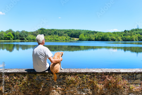 Man with dog sitting on wall