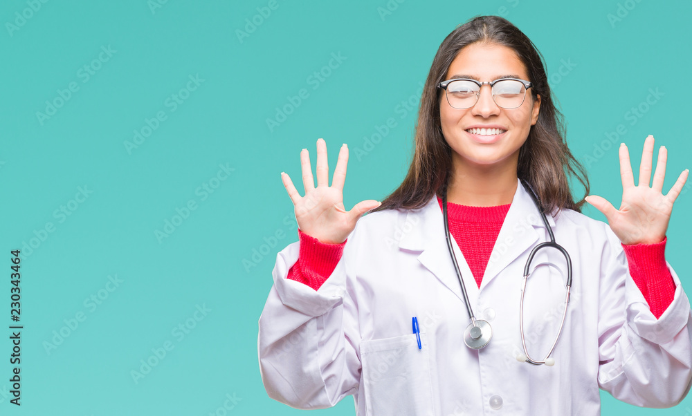 Young arab doctor woman over isolated background showing and pointing up with fingers number ten while smiling confident and happy. Young arab doctor woman over isolated background showing and pointing up with fingers number ten while smiling confident and happy.
