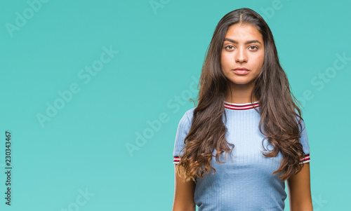 Young beautiful arab woman over isolated background with serious expression on face. Simple and natural looking at the camera. photo