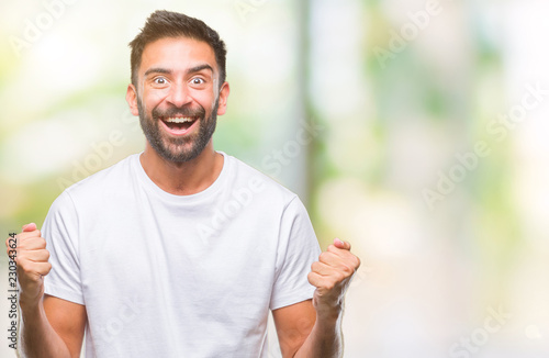 Adult hispanic man over isolated background celebrating surprised and amazed for success with arms raised and open eyes. Winner concept. © Krakenimages.com