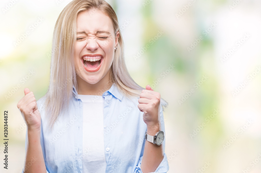 Young blonde woman over isolated background excited for success with arms raised celebrating victory smiling. Winner concept. Young blonde woman over isolated background excited for success with arms raised celebrating victory smiling. Winner concept.