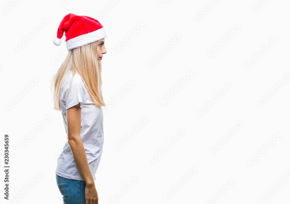 Young beautiful blonde woman christmas hat over isolated background looking to side, relax profile pose with natural face with confident smile. Young beautiful blonde woman christmas hat over isolated background looking to side, relax profile pose with natural face with confident smile.