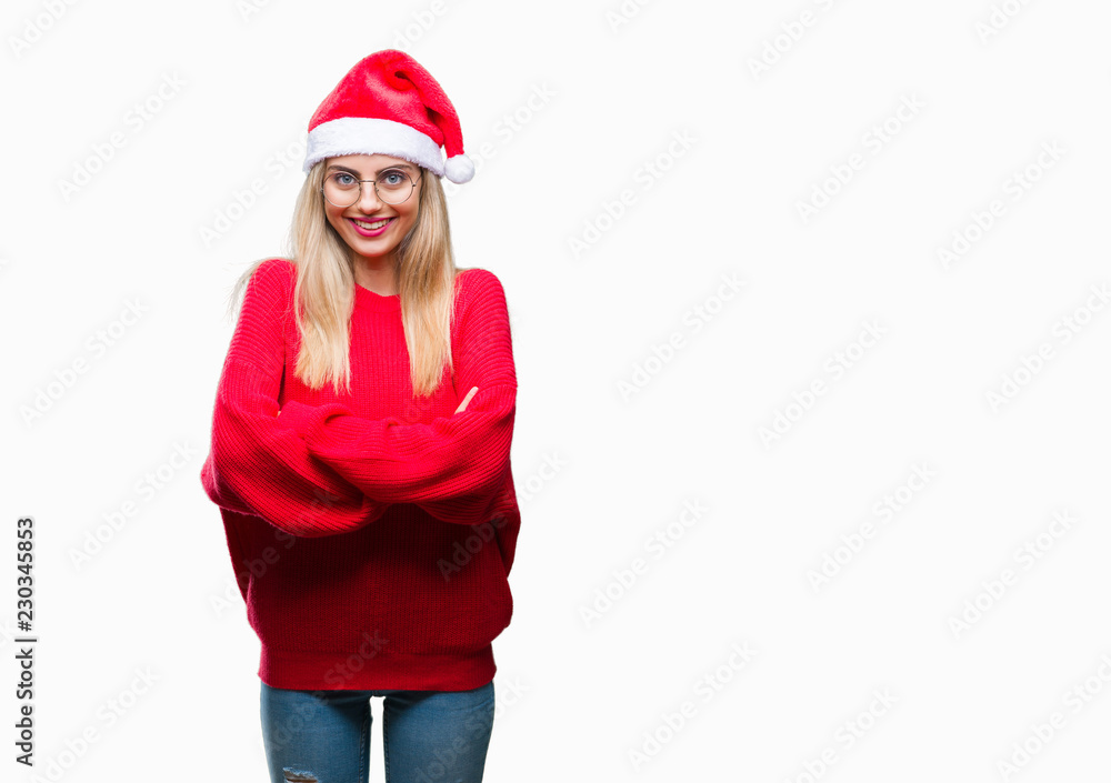 Young beautiful blonde woman wearing christmas hat over isolated background happy face smiling with crossed arms looking at the camera. Positive person. Young beautiful blonde woman wearing christmas hat over isolated background happy face smiling with crossed arms looking at the camera. Positive person.