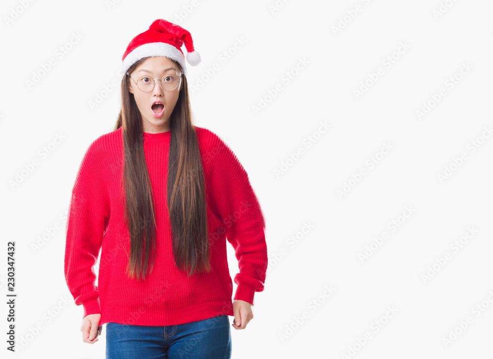 Young Chinese woman over isolated background wearing christmas hat afraid and shocked with surprise expression, fear and excited face. Young Chinese woman over isolated background wearing christmas hat afraid and shocked with surprise expression, fear and excited face.