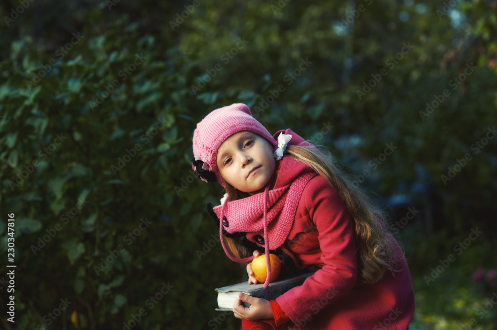 portrait of a girl in an autumn Park, a child dressed in a red warm coat