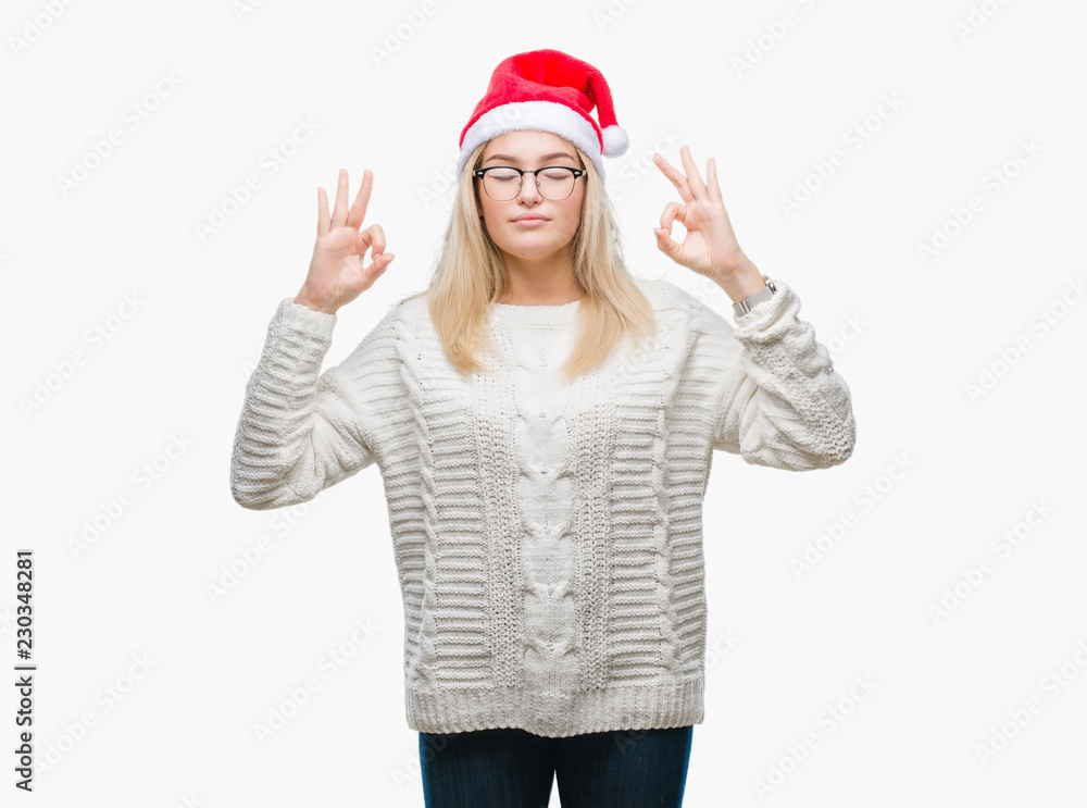 Young caucasian woman wearing christmas hat over isolated background relax and smiling with eyes closed doing meditation gesture with fingers. Yoga concept. Young caucasian woman wearing christmas hat over isolated background relax and smiling with eyes closed doing meditation gesture with fingers. Yoga concept.