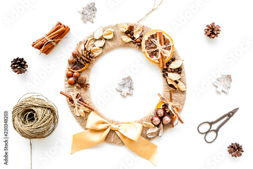 Christmas decoration concept. Creative christmas wreath made of thread near matherials and instruments, sciccors on white background top view