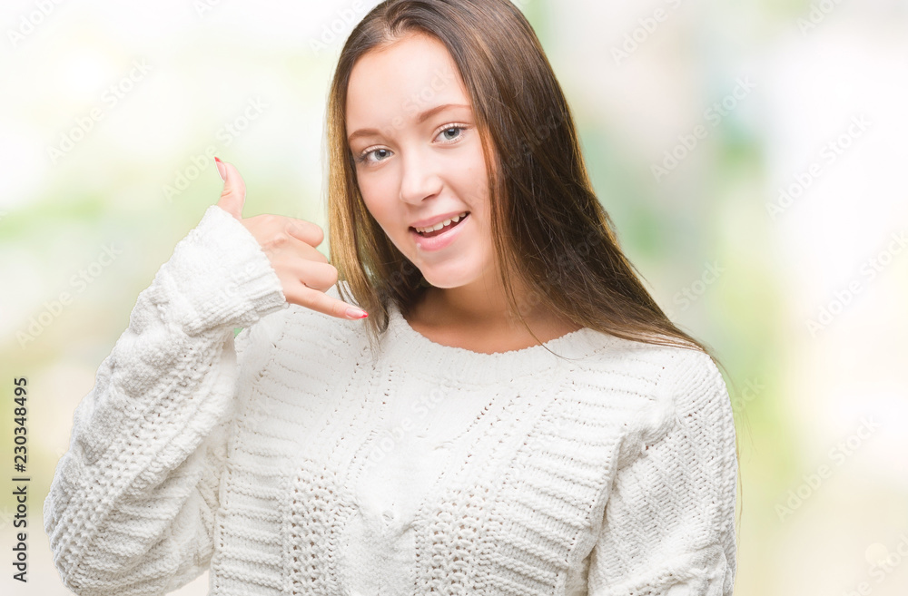 Young beautiful caucasian woman wearing winter sweater over isolated background smiling doing phone gesture with hand and fingers like talking on the telephone. Communicating concepts.