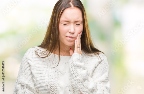 Young beautiful caucasian woman wearing winter sweater over isolated background touching mouth with hand with painful expression because of toothache or dental illness on teeth. Dentist concept.