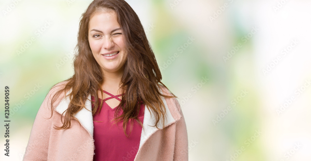 Beautiful plus size young woman wearing winter coat over isolated background winking looking at the camera with sexy expression, cheerful and happy face. Beautiful plus size young woman wearing winter coat over isolated background winking looking at the camera with sexy expression, cheerful and happy face.