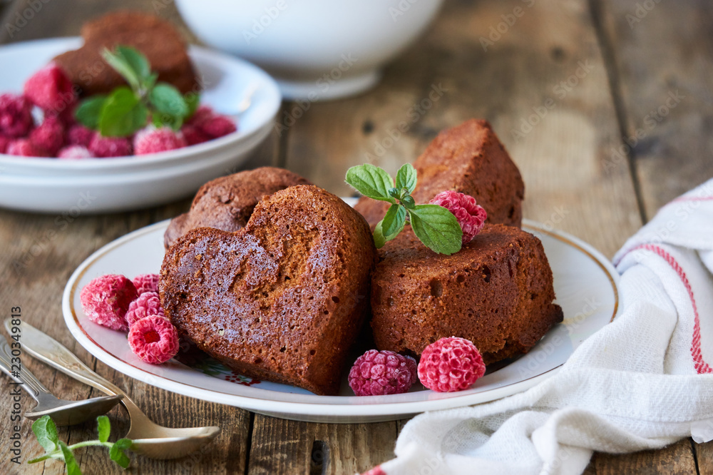 Chocolate cupcakes with fresh raspberries and mint on a plate Chocolate cupcakes with fresh raspberries and mint on a plate