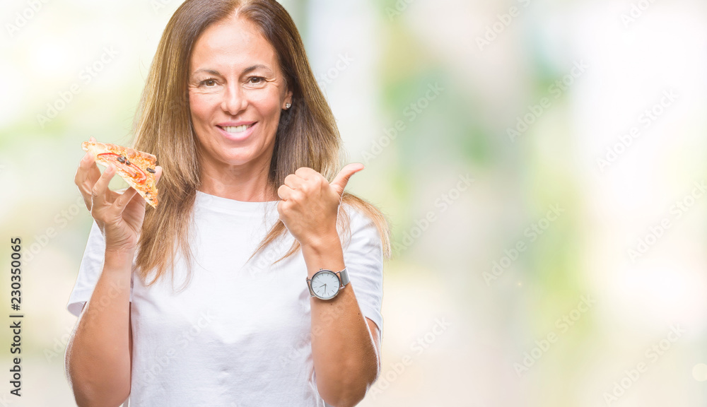 Middle age hispanic woman eating pizza slice over isolated background happy with big smile doing ok sign, thumb up with fingers, excellent sign