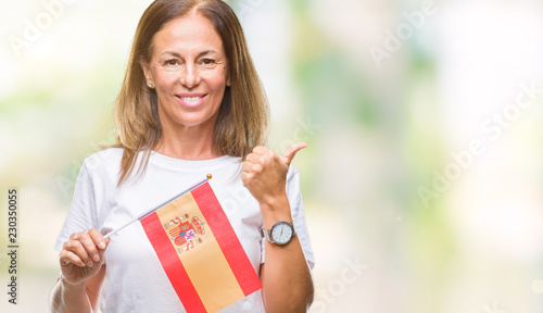 Valokuva Middle age hispanic woman holding flag of Spain over isolated background happy w
