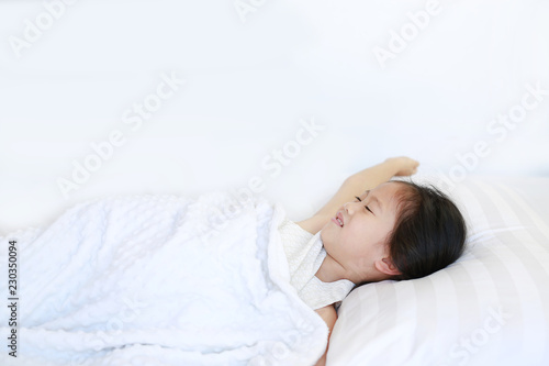 Portrait of beautiful Asian child girl lying on bed.