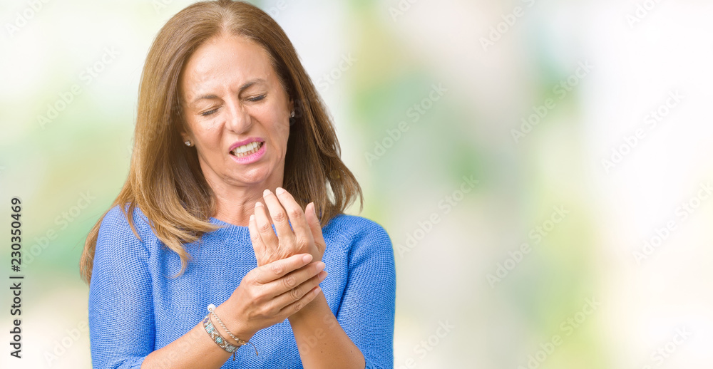 Middle age beautiful woman wearing winter sweater over isolated background Suffering pain on hands and fingers, arthritis inflammation