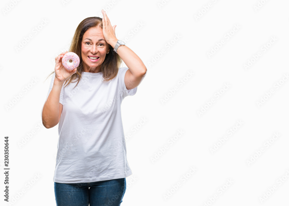 Middle age hispanic woman eating pink donut over isolated background stressed with hand on head, shocked with shame and surprise face, angry and frustrated. Fear and upset for mistake. Middle age hispanic woman eating pink donut over isolated background stressed with hand on head, shocked with shame and surprise face, angry and frustrated. Fear and upset for mistake.