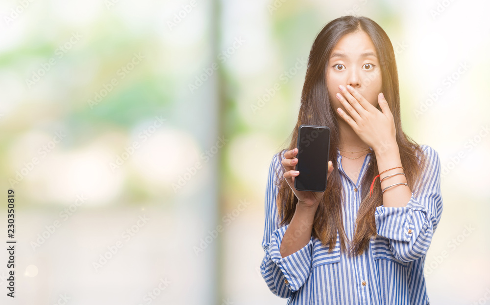 Young asian woman showing blank screen of smartphone over isolated background cover mouth with hand shocked with shame for mistake, expression of fear, scared in silence, secret concept Young asian woman showing blank screen of smartphone over isolated background cover mouth with hand shocked with shame for mistake, expression of fear, scared in silence, secret concept