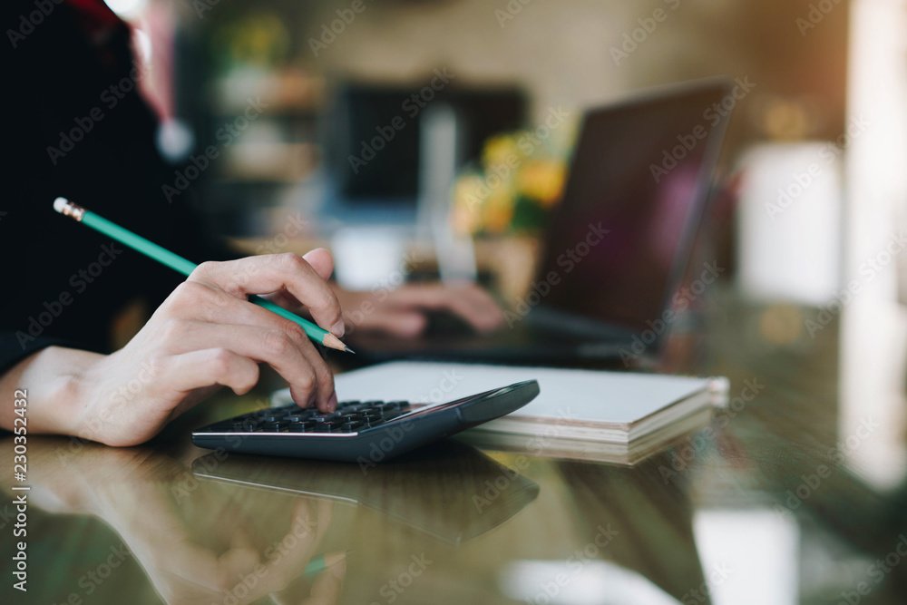 Businesswoman hand pressing on calculator for calculating cost estimating. Businesswoman hand pressing on calculator for calculating cost estimating.