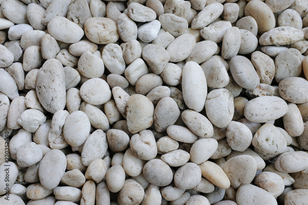 White natural river rocks and pebbles background texture