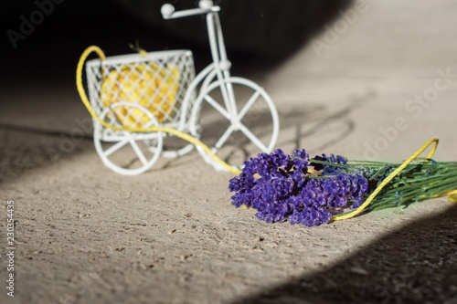 Fototapeta Naklejka Na Ścianę i Meble -  A small decorative figure of a white bicycle. Purple lavender flowers.