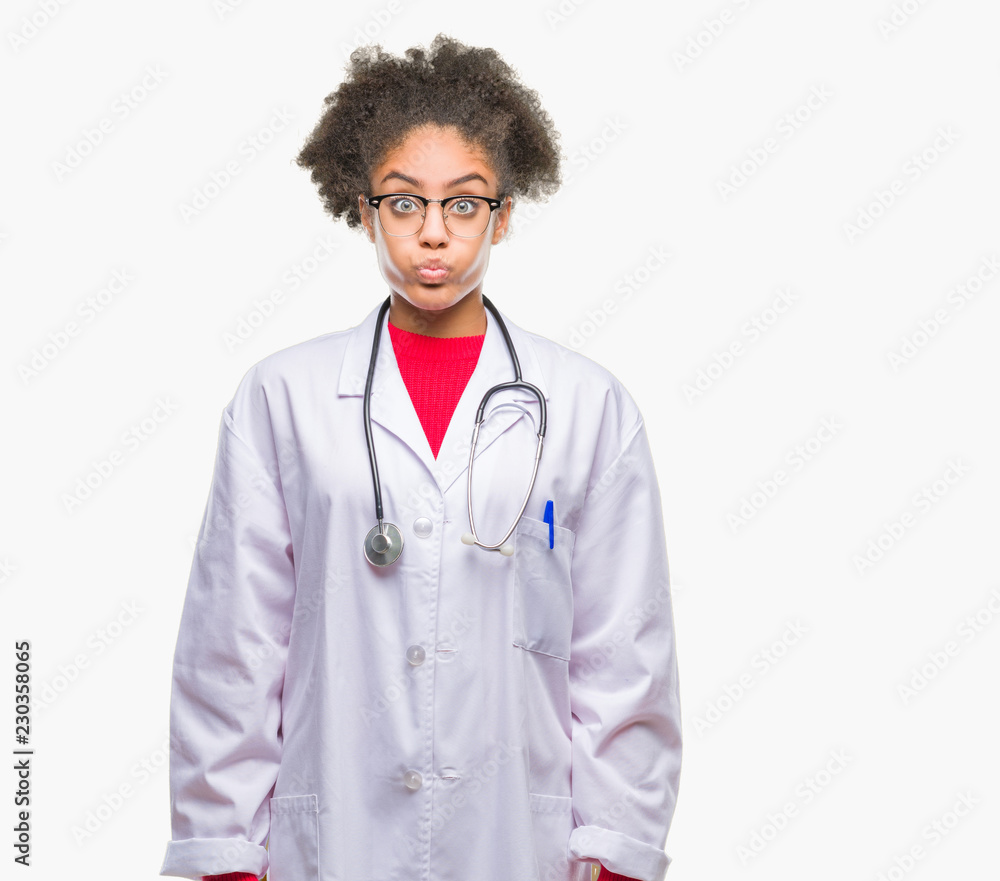 Young afro american doctor woman over isolated background puffing cheeks with funny face. Mouth inflated with air, crazy expression. Young afro american doctor woman over isolated background puffing cheeks with funny face. Mouth inflated with air, crazy expression.