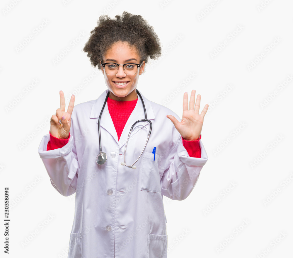 Young afro american doctor woman over isolated background showing and pointing up with fingers number seven while smiling confident and happy. Young afro american doctor woman over isolated background showing and pointing up with fingers number seven while smiling confident and happy.