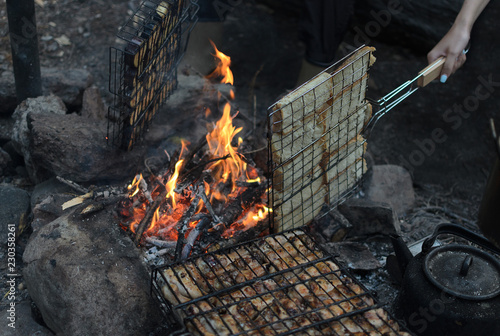 Cooking on a campfire grill. Dinner on Lake Baikal coast