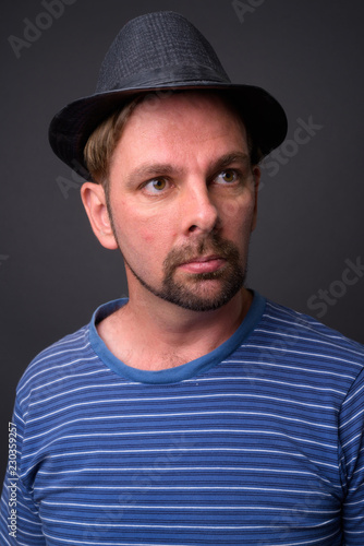 Blond bearded tourist man with goatee against gray background