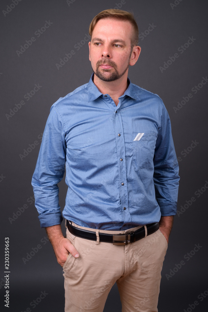 Blond bearded businessman with goatee against gray background Blond bearded businessman with goatee against gray background