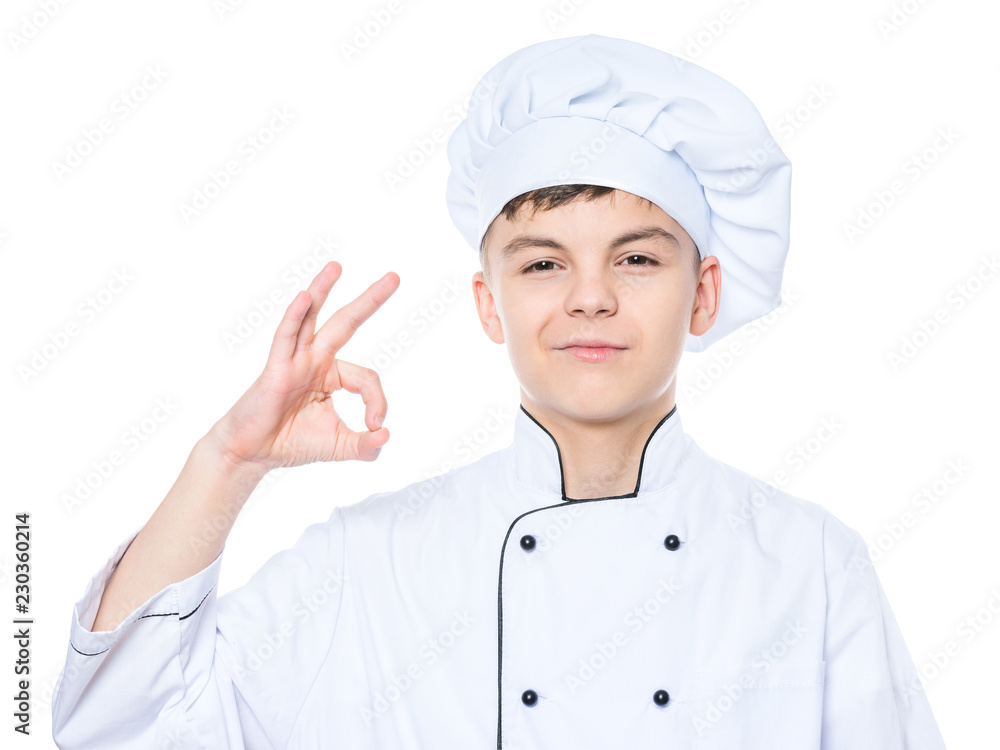 Handsome teen boy wearing chef uniform making ok gesture. Portrait of a happy cute male child cook, isolated on white background. Food and cooking concept. Handsome teen boy wearing chef uniform making ok gesture. Portrait of a happy cute male child cook, isolated on white background. Food and cooking concept.