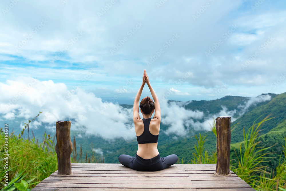 Healthy woman lifestyle balanced practicing meditate and zen energy yoga on the bridge in morning the mountain nature. Healthy life Concept. - obrazy, fototapety, plakaty 