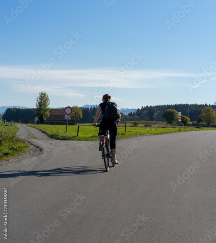 Girl cycling into the mountains
