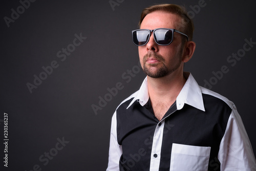 Blond bearded businessman with goatee against gray background