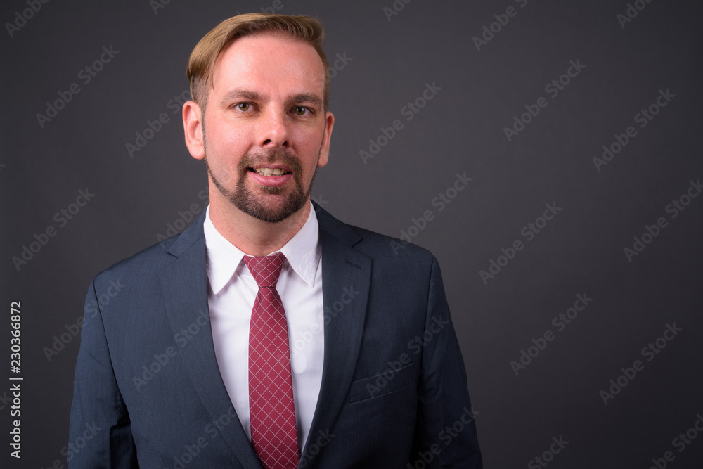 Blond bearded businessman with goatee against gray background Blond bearded businessman with goatee against gray background