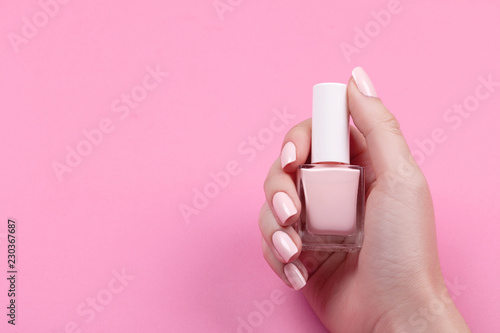 girl holds nail polish with a beautiful manicure photo