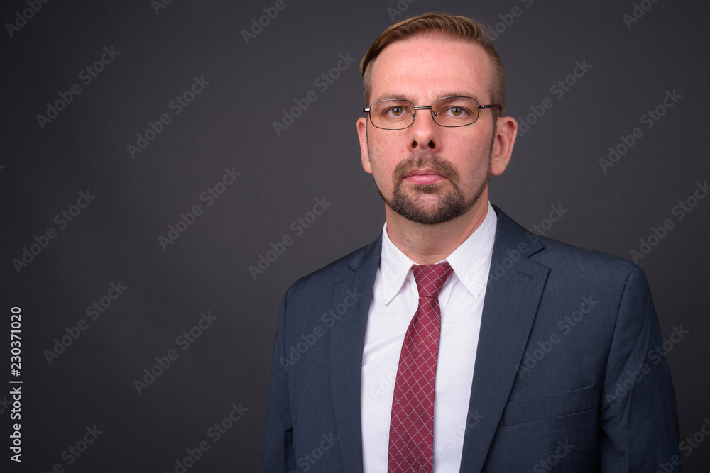 Blond bearded businessman with goatee against gray background Blond bearded businessman with goatee against gray background