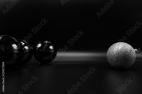 Black and glittered silver Christmas balls on black.