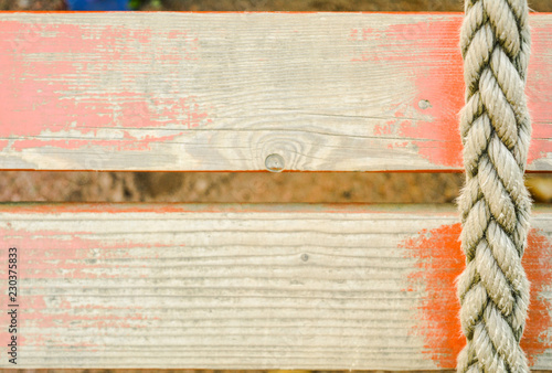 Old rope and distressed red painted wood planks
