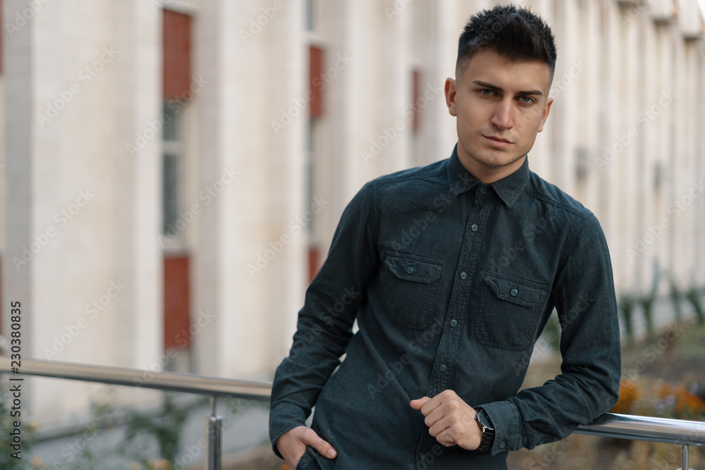 Obraz premium Portrait of a handsome young casual guy posing on street backgro