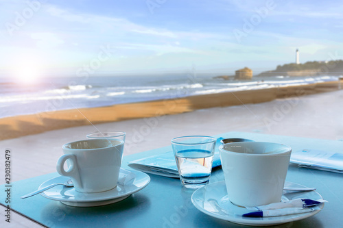 Cup of coffee with a sweet cake and croissant. Concept of good morning, tasty breakfast in hotel outside on the terrace with sea view.