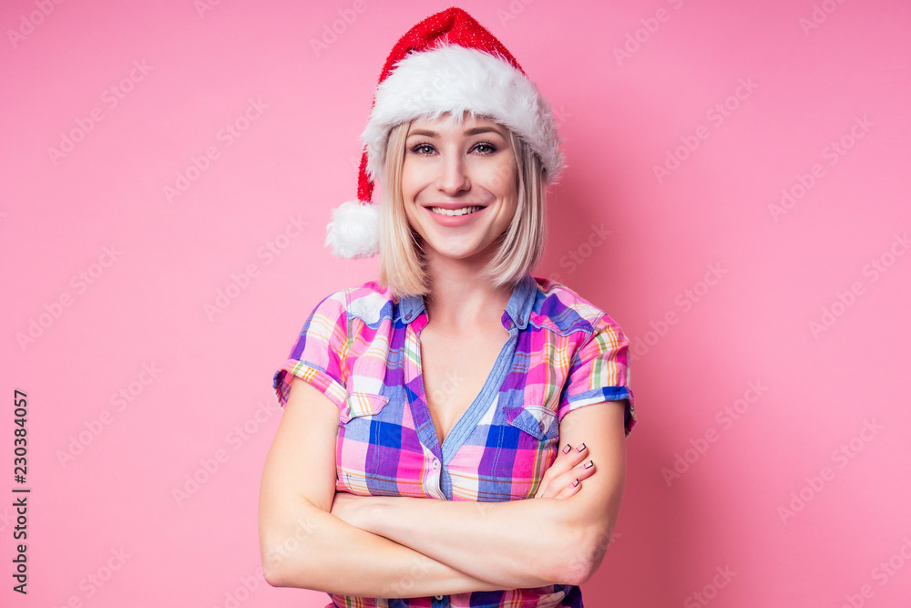 portrait of young Beautyful blondу amazed woman with christmas box gift on red background. lady in a plaid shirt and santa claus hold a bag full of presents on a pink background in the studio portrait of young Beautyful blondу amazed woman with christmas box gift on red background. lady in a plaid shirt and santa claus hold a bag full of presents on a pink background in the studio
