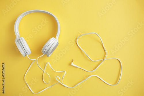 Modern headphones on color background